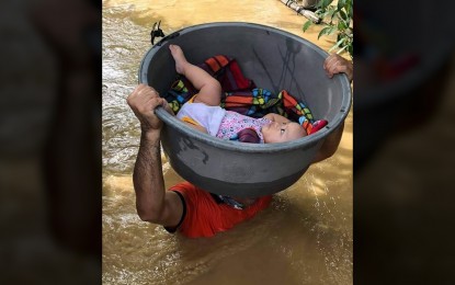 <p><strong>RESCUE. </strong>Chief Petty Officer Romyr Ballen of the Philippine Coast Guard (PCG) District North Eastern Luzon carries a baby over chest-deep floodwaters in Barangay Linao Norte, Tuguegarao City, Cagayan on Friday (Nov. 13, 2020). Ballen is one of several PCG personnel rescuing 195 individuals in the flood-hit provinces of Cagayan and Isabela. (<em>Photo courtesy of PCG</em>)  </p>