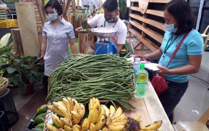 <p><strong>GUARANTEED MARKET. </strong>Judith Sagbigsal (right) of the Kilometer 7 Farmers Producers Cooperative (K7FPC) supervises the selling of vegetables and other agricultural products at the Kadiwa Market facilitated by the Department of Agriculture-13 at Robinson’s Place in Butuan City on Saturday, Nov. 14, 2020. The K7FPC and eight other farmers’ groups lauded the Kadiwa program for providing the farmers with a reliable market for their products to stay profitable amid the coronavirus pandemic.<em> (PNA photo by Alexander Lopez)</em></p>