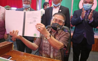 <p><strong>BARMM ADMINISTRATIVE LAW.</strong> Bangsamoro Autonomous Region in Muslim Mindanao Chief Minister Ahod Ebrahim shows the new regional administrative code that he signed into regional law on Tuesday (Nov. 17, 2020). The new BARMM governmental law will define the structure and rules of governance of the region.<em> (Photo courtesy of BPI-BARMM)</em></p>