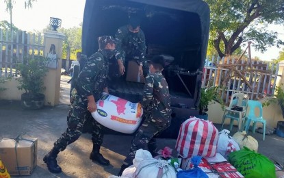 <p><strong>RELIEF OPS</strong>. Members of the Philippine Air Force (PAF) carry relief goods donated by villagers in Nalvo, Pasuquin, Ilocos Norte to flood victims in Cagayan. Since Friday (Nov. 20, 2020), the provincial government of Ilocos Norte has temporarily suspended its donation drive as three of its employees were tested positive for Covid-19. (<em>Photo courtesy of Edison Barneso</em>)  </p>