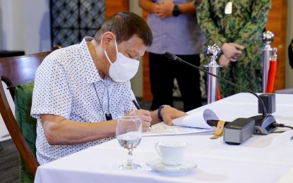 <p><strong>TALK TO THE PEOPLE</strong>. President Rodrigo R. Duterte skims through a document as he presides over a meeting with the Inter-Agency Task Force on the Emerging Infectious Diseases (IATF-EID) core members before his talk to the people at the Arcadia Active Lifestyle Center in Davao City on Nov. 23, 2020. Malacañang on Tuesday (Nov. 24, 2020) said Duterte refuses to name congressmen who allegedly received kickbacks from project contractors due to “lack of sufficient evidence.” <em>(Presidential photo by Joel Dalumpines)</em></p>