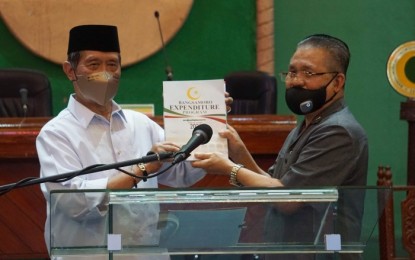 <p><strong>PROPOSED BARMM 2021 BUDGET.</strong> Bangsamoro Autonomous Region in Muslim Mindanao Minister Ahod Ebrahim (right) presents before members of the Bangsamoro Transition Authority, the region’s lawmaking body, the proposed 2021 regional budget on Thursday (Nov. 26, 2020). Standing on the left is BTA parliament speaker Pangalian M. Balindong.<em> (Photo courtesy of BPI-BARMM)</em></p>
