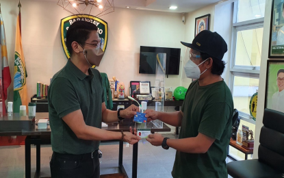 <p><strong>BARANGAY SCHOLAR</strong>. Barangay San Antonio chairman Raymond Lising hands over an ATM card and citizen card to one of the barangay’s 87 scholars. Lising said each scholar will receive PHP50,000 maximum per year and a monthly allowance of PHP1,500 via electronic money transfer (e-money). <em><strong>(Photo courtesy of Barangay San Antonio)</strong></em></p>