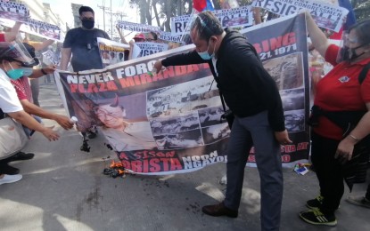 <p><strong>RESIGN</strong>. Rallyists burn a tarpaulin bearing the image of Communist Party of the Philippines founding chairman Joma Sison during a rally at the Senate grounds on Tuesday (Dec. 1, 2020). The anti-communist groups and other civil society organizations group called on the Makabayan bloc legislators to resign and denounce the Communist Party of the Philippines-New People’s Army’s terroristic attacks. <em>(PNA photo by Lade Kabagani)</em></p>