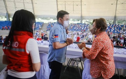 <p><strong>HELP FOR BULAKENYOS</strong>. Senator Bong Go (middle) and Bulacan 3rd District Representative Lorna Silverio (right) exchange pleasantries during the latter’s visit in Bulacan on Dec. 2. Silverio expressed gratitude on behalf of Bulakeños for helping the victims of Typhoon Ulysses and for the Malasakit Centers Go established in the province. In the background, are the beneficiaries assembled in Norzagaray by local officials led by Gov. Daniel Fernando and host Mayor Alfredo Germar. (<strong>PNA</strong>)</p>