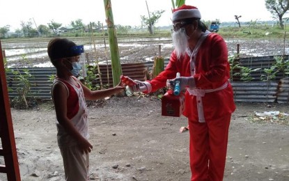 <p><strong>MY TEACHER, MY SANTA CLAUS</strong>. Roselle del Rosario Mananggit, a Grade 2 teacher of Mangino Elementary School in Gapan City, Nueva Ecija, plays Santa Claus to her pupils as a way of rewarding them for diligently answering their learning modules. She said she wants the children to feel the spirit of Christmas amid the Covid-19 pandemic. <em>(Photo courtesy of Roselle del Rosario Mananggit)</em></p>