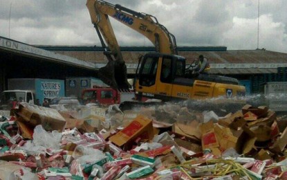 <p><strong>DESTROYED.</strong> A backhoe crushes smuggled cigarettes worth PHP183 million in Zamboanga City on Monday (Dec. 7, 2020). The cigarettes destroyed by the BOC-Zamboanga were then transported and disposed in city's sanitary landfill in Barangay Salaan. <em>(Photo courtesy of Remus Lim Ong)</em></p>