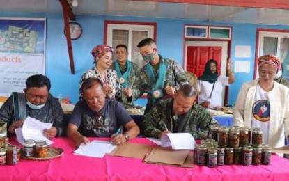 <p><strong>LIVELIHOOD PACT.</strong> The 4th Marine Brigade (MBde) and the municipality of Banguingui, Sulu sign on Dec. 6, 2020 a memorandum of understanding (MOU) as partners to promote, develop, and market the seafood products of the Banguingui Women Livelihood Multi-Purpose Cooperative. The signatories were Col. Ruben Candelario, 4MBde commander (seated, right), and officials of the cooperative and municipality of Banguingui, formerly known as Tongkil town. <em>(Photo courtesy of 4MBde)</em></p>
