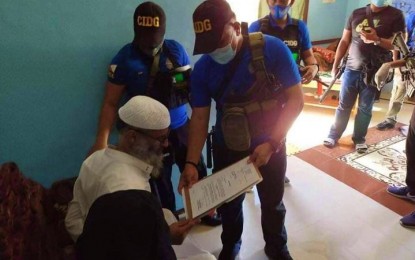 <p><strong>NABBED</strong>. Members of police’s Criminal Investigation and Detection Group (CIDG) present the search warrant issued by a local court to Saudi national Abdel Solaiman Alsuhibani, a suspected Islamic State of Iraq and Syria member operating in East Asia with alleged links to  Maguindanao-based terrorist group Bangsamoro Islamic Freedom Fighters. (<em>Photo courtesy of CIDG-BARMM</em>)</p>