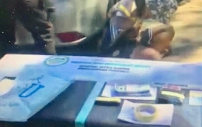 <p><strong>NABBED.</strong> Drug suspect Allan Sambutan Abdul hides his face following his arrest during an entrapment operation on Thursday morning (Dec. 10, 2020) in Barangay Capiton, Datu Odin Sinsuat, Maguindanao. Abdul yielded some 100 grams of shabu with an estimated street value of PHP680,000 and other pieces of evidence. <em>(Photo courtesy of PDEA-BARMM)</em></p>