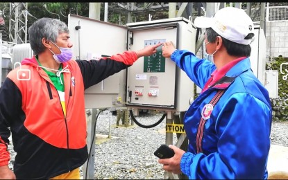 <p><strong>SWITCH ON</strong>. Buguias Vice Mayor Dionne Baucas (left), and Barangay Amgaleyguey, Buguias Chairman John Puddong (right), turn the power button on of the 10 megavolt (MV) amphere Sinipsip sub-station of the Benguet Electric Cooperative on Friday (Dec. 11, 2020). The commissioning of the sub-station is to provide reliable electricity 24/7 to its consumers in northern Benguet. (<em>PNA photo by Liza T. Agoot</em>) </p>