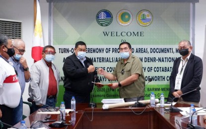 <p><strong>ENVIRONMENT PROTECTION TURNOVER.</strong> DENR Undersecretary Jim Sampulna (3rd, left) and MENRE-BARMM Minister gesture the “fist-bump” after the turnover of BARMM protected areas previously under the care of Regions 9, 10, and 12. The protected assets included the Turtle Islands Wildlife Sanctuary in Region 9, the Lake Lanao Watershed in Region 10, and the Liguasan Marsh in Region 12. <em>(Photo courtesy of MENRE-BARMM)</em></p>