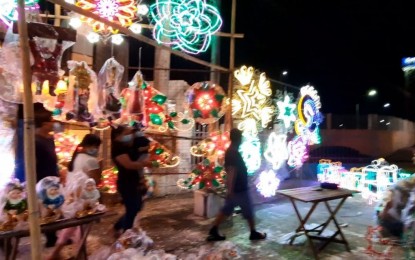 <p>People buy lanterns in San Fernando, Pampanga. Lantern makers say they will continue to make and sell "parol" to boost the holiday cheer amid the pandemic. <em>(Photo by Marita Moaje)</em></p>
