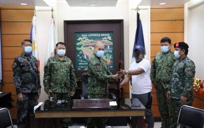 <p><strong>BACK TO THE FOLD</strong>. A rebel hands over a firearm to Police Eastern Visayas regional director, Brig. Gen. Ronaldo de Jesus, in this Dec. 10, 2020 photo. Despite the pandemic, Eastern Visayas region has been gaining ground in its fight against the communist terrorist group New People’s Army (NPA) this year with the dismantling of more guerrilla fronts and persuading more rebel fighters to surrender. <em>(Photo courtesy of Philippine National Police Region 8)</em></p>
<p> </p>