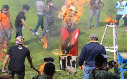 <p><strong>MASS SURRENDER.</strong> Former members of the New People’s Army torch an effigy representing the communist movement during their formal surrender in Butuan City on Saturday (Dec. 26, 2020), the 52nd founding anniversary of the Communist Party of the Philippines. The 32 surrenderers were from Agusan del Norte. <em>(Photo courtesy of ADNPPO)</em></p>