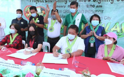 <p><strong>URBAN FARMING IN QC.</strong> DAR Secretary John Castriciones (center) and Quezon City Mayor Joy Belmonte (2nd from left) sign a memorandum of understanding for the "Buhay sa Gulay" urban farming project in Barangay Bagong Silangan on Friday (Jan. 8, 2021). The Quezon City government allotted seven-hectare of land at the New Greenland Farm in Barangay Bagong Silangan for the project. <em>(PNA photo by Joey Razon)</em></p>