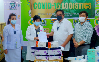 <p><strong>BATTLING COVID-19.</strong> BARMM Executive Secretary Abdulraof Macacua (2nd from right) and Dr. Helen Quiambao, chief of Cotabato Regional and Medical Center (2nd from left) show the deed of donation of health logistics during turnover rites Thursday (Jan. 7, 2021) at the MOH-BARMM office. MOH-BARMM acting minister Dr. Amirel Usman said similar logistics will be turned over to hospitals and health offices in the island-provinces of Basilan, Sulu, and Tawi-Tawi next week.<em> (Photo from BIO-BARMM)</em></p>