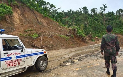 <p><strong>LANDSLIDE</strong>. Police personnel are shown monitoring a landslide area in Barangay Bagumbayan in Bato, Catanduanes in an undated photo. Heavy rains on Saturday and Sunday triggered floods and landslides in Bicol provinces, affecting over 400 people.<em> (Photo courtesy of the Bato Municipal Police Station)</em></p>