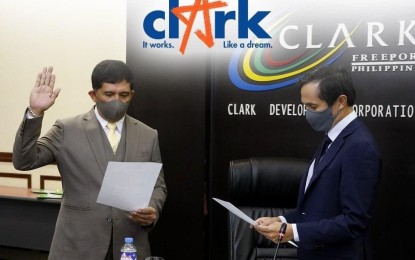 <p><strong>OATHTAKING</strong>. Vince Dizon (right), chair of the Clark Development Corp. (CDC), administers the oath of board member Manuel R. Gaerlan as the new president of the CDC during a regular board meeting held at the Clark Special Economic Zone in Pampanga on Thursday (Jan. 14, 2021). Gaerlan immediately met with the CDC team to set his plans in motion.<em> (Photo by CDC)</em></p>