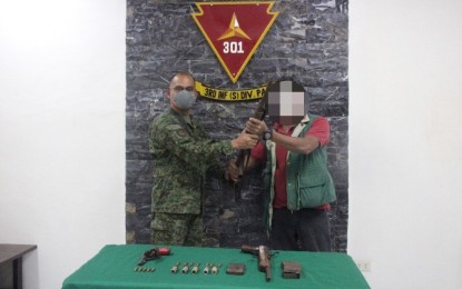 <p><strong>SURRENDER</strong>. Alias Sam (right), turns himself in to the military on Monday (Jan. 18, 2021), bringing with him firearms and ammunitions that he surrendered to Col. Orlando Edralin (left), officer-in-charge of the 301st Infantry Brigade, Philippine Army. He is already the 310th supporter of the NPA who surrendered in Panay Island from January 1 to date.<em> (PNA photo courtesy of 301st Infantry Brigade)</em></p>