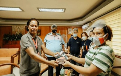 <p><strong>HONEST DPWH MAN.</strong> Bernardo de la Cruz (left) hands over the bag containing PHP360,000 cash to its rightful owner, Jean A. Hinayon (right), supervisor and cashier of San Isidro Upland Farmers Multipurpose Cooperative in the town of Santiago, Agusan del Norte. The turnover on Friday (Jan. 22, 2021) at the DPWH-13 office was witnessed by Regional Director Pol delos Santos (2nd from left). <em>(Photo courtesy of DPWH Caraga)</em></p>