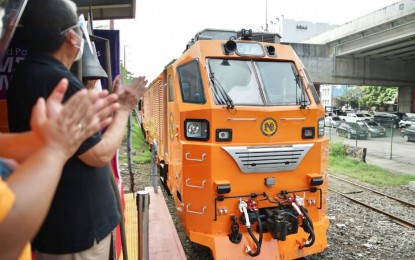 <p><strong>NEW TRAINS.</strong> Department of Transportation Secretary Arthur Tugade and other officials clap their hands in celebration of the arrival at the Tutuban station in Manila of one of the Philippine National Railways' new Diesel Hydraulic Locomotives on Thursday (Jan. 28, 2021). Three new DHLs, composed of a total of 15 passenger coaches, are one of the PNR's highest capacity trains and will serve the Tutuban-Los Baños line. <em>(Photo courtesy of DOTr)</em></p>