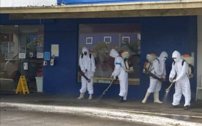 <p><strong>DISINFECTION</strong>. The decontamination team of the City Disaster Risk Reduction and Management Office disinfects the area outside the building of business outsourcing firm Transcom in Bacolod City on Monday (Feb. 1, 2021). The facility has been closed for 24 hours since Sunday night after 41 of its call center agents tested positive for Covid-19. <em>(Photo courtesy of Adrian Bobe)</em></p>