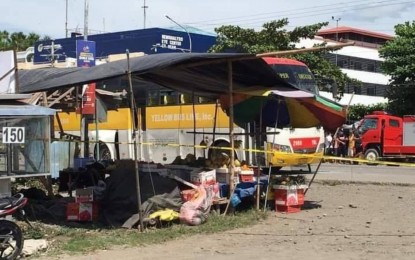 <p><strong>EXTORTION TARGET.</strong> A unit of the Yellow Bus Line (partly hidden) that was allegedly targeted by the Al Khobar extortion group during the Jan. 27, 2021 bombing in Barangay Sibsib, Tulunan, North Cotabato. No one was hurt among the passengers, but the blast that occurred at a drop point killed a fruit vendor and wounded three bystanders.<em> (Photo courtesy of Tulunan MPS)</em></p>