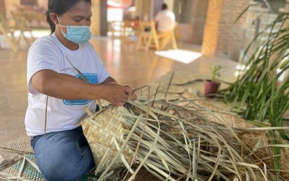 <p><strong>EXHIBIT. </strong>A basket maker in Pagudpud, Ilocos Norte demonstrates her craft on Tuesday (Feb. 2, 2021) as part of the Ilocano Creatives Fest. The festival aims to promote the work of artisans as Ilocos Norte celebrates its 203rd founding anniversary. (<em>PNA photo by Leilanie G. Adriano</em>) </p>