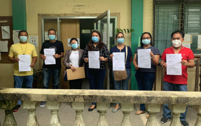 <p><strong>POSTED BAIL</strong>. Vice Mayor Lord Dean Castillo of Isulan, Sultan Kudarat (in red shirt), and five other town officials accused of graft show their papers after posting bail before the local court on Tuesday (Feb. 2, 2021). The officials earlier denied reports circulating on social media that they have been arrested, saying they voluntarily went to the court to post the required bail bond. (<em>Photo courtesy of Isulan VM Castillo)</em></p>