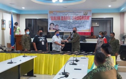 <p><strong>SURRENDERED GUNS.</strong> Brig. Gen. Roberto Capulong, Army’s 602nd Infantry Brigade commander, receives a rifle from Mayor Ohto Montawal of Datu Montawal town in Maguindanao during turnover rites held Thursday (Feb. 4, 2021) for unlicensed guns collected from residents. A total of 12 firearms were handed over by the local officials to the military. <em>(Photo courtesy of 602nd Brigade)</em></p>