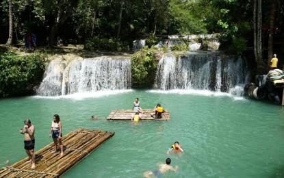 <p><strong>TOURISM RESTART</strong>. European and Chinese tourists enjoy the light green clear water at the three-tiered Cambugahay Falls in Barangay Kinamandagan, Lazi, Siquijor in this undated photo. The island is looking to reopen its tourism industry as part of the local government's recovery plan amid the coronavirus disease pandemic, Governor Zaldy Villa said on Saturday (Feb. 6, 2021). <em>(PNA file photo by Ben Briones)</em></p>
