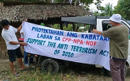 <p><strong>NO TO TERRORISM.</strong> Subanen tribal leaders hang streamers Saturday (Feb. 6, 2021) along the national highway in Gutalac, Zamboanga del Norte, to express support for the Anti-Terrorism Act of 2020. They also called on critics of the law to look into the plight of the victims of abuses committed by the New People's Army and other lawless groups.<em> (Photo by Leah D. Agonoy)</em></p>