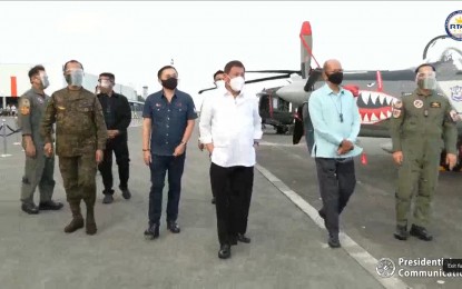 <p><strong>NEW COMBAT HELICOPTERS</strong>. President Rodrigo Duterte inspects the newly-delivered air assets displayed at the Haribon Hangar of the Clark Air Base in Pampanga accompanied by Senator Christopher "Bong" Go (left) and Defense Secretary Delfin Lorenzana (right) on Friday (Feb. 12, 2021). In a speech, Duterte was confident that the delivery of new combat helicopters would inspire the military more to fulfill their duty to serve and protect the country. <em>(Screengrab from RTVM)</em></p>