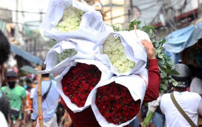 <p><strong>BUNCH OF ROSES.</strong> A man carries a bunch of roses on his shoulder along Dos Castillas Street in Sampaloc, Manila on Saturday (Feb. 13, 2021). Giving roses to someone is the most popular gift to express one’s love during Valentine’s Day.<em> (PNA photo by Joey O. Razon)</em></p>