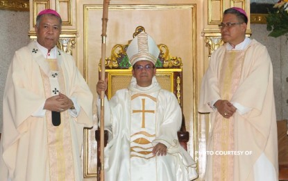 <p>Basilan Bishop Leo Dalmao (center).<em> (File photo)</em></p>