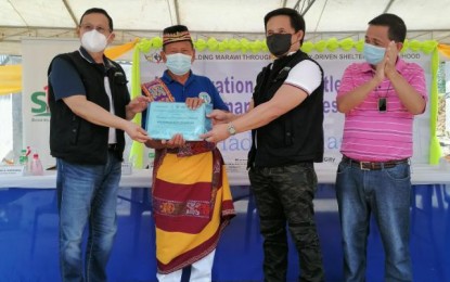 <p><strong>PERMANENT HOUSES</strong>. TFBM Chairperson Secretary Eduardo del Rosario (left), Marawi Mayor Majul Gandamra (right, with black mask), and Social Housing Finance Corporation president Arnolfo Ricardo Cabling (far right) conduct the ceremonial distribution of permanent house certificates on Thursday (Feb. 25, 2021). The TFBM also inaugurates the Marawi Resettlement Site and Permanent Houses (Phase 1) in Barangay West Dulay in Marawi City. <em>(Contributed photo)</em></p>