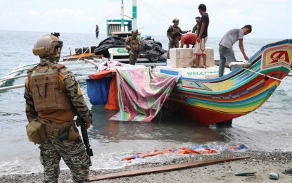 <p><strong>SMUGGLED GOODS.</strong> A Navy personnel stands guard while two of his companions supervise the unloading of smuggled cigarettes from a fishing boat at the shore of Naval Station Romulo Espaldon in Zamboanga City. The fishing boat, Princess Arlyn, loaded with some PHP17.3 million worth of smuggled assorted cigarettes was intercepted by the operatives of the Naval Task Group-Sulu on Tuesday (Feb. 23, 2021) in Karangdato Point, Kalingalan Caluang, Sulu. The shipment was believed to have come from Indonesia and was bound to Cotabato City. <em>(Photo courtesy of Naval Forces Western Mindanao Public Information Office)</em></p>