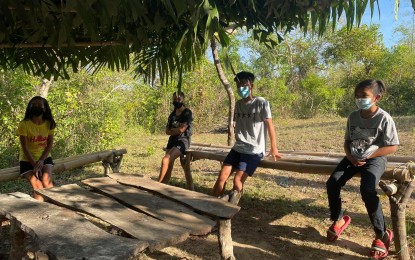 <p><strong>WAITING GAME</strong>. Young learners in Barangay Sumader, Batac City, Ilocos Norte stay in a makeshift structure where communication signal is strong in this undated photo. Based on a local survey conducted by the Schools Division of Ilocos Norte, the distance learning system has been taking a toll not just on students, but also on adults supervising the new mode of education. <em>(File photo by Leilanie G. Adriano)</em></p>