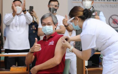 <p><strong>HISTORIC.</strong> Philippine General Hospital Director Dr. Gerardo Legaspi flashes a thumbs up sign while he gets vaccinated with the CoronaVac shortly after 9 a.m. on Monday (March 1, 2021), opening a new chapter in the battle against the coronavirus. There was plenty of applause as cameras capture the inoculation procedure, the first step in getting past the pandemic. <em>(PNA photo by Joey O. Razon)</em></p>