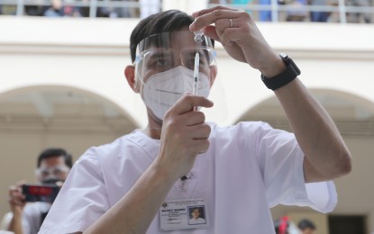 <p><strong>DOSE OF HOPE.</strong> A medical personnel gets ready to administer a jab at the Philippine General Hospital on the first day of the vaccine rollout in Manila last Monday (March 1, 2021). At the Philippine National Police, some 305 medical front-liners have received their CoronaVac vaccine shots in the first two days of the vaccination rollout. <em>(PNA photo by Joey O. Razon)</em></p>