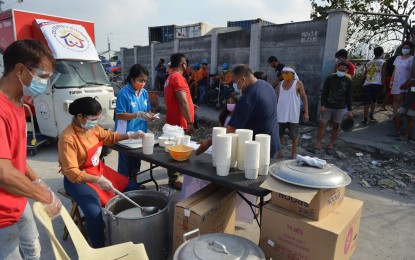 <p><strong>DUTERTE’S KITCHEN.</strong> Duterte’s Kitchen provides 2,000 hot meals for the victims of fire that left 500 families homeless at the Parola Compound in Tondo, Manila on Feb. 22, 2021. Duterte’s Kitchen was organized by Cusi in 2016. <em>(Photo courtesy of Secretary Al Cusi’s office)</em></p>