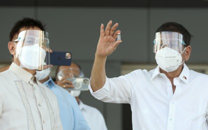 <p><strong>HOPE IN A DOSE.</strong> President Rodrigo Duterte holds a vial of CoronaVac upon welcoming the arrival of the vaccines on February 28, 2021.  The government is working aggressively to ensure that the country gets a stable supply of vaccines starting April or May.<em> (Presidential Photo)</em></p>