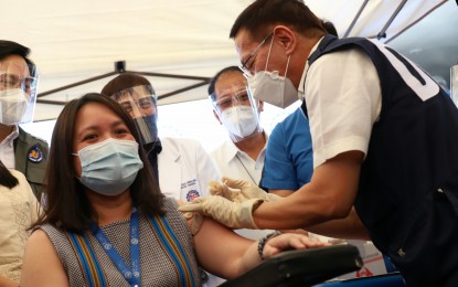 <p><strong>PROTECTION.</strong> Health Secretary Francisco Duque III administers the Covid-19 vaccination to one of the healthcare personnel in St. Luke's Medical Center. Vaccination against coronavirus disease is vital in preventing the surge of Covid-19 cases in the country.<em> (PNA file photo) </em></p>
