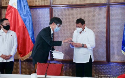 <p><strong>NEW PhilID RECIPIENT</strong>. President Rodrigo Duterte on March 3, 2021 received his government-issued PhilID which will serve as a national identity card for Filipino citizens and resident aliens in the Philippines. Duterte got his PhilID from Acting Socioeconomic Planning Secretary Karl Kendrick Chua. <em>(Presidential Photo)</em></p>