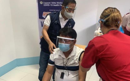 <p><strong>FIRST VACCINEE</strong>. Dr. Glenn Mathew Baggao, Cagayan Valley Medical Center chief (seated), on Sunday (March 7, 2021) receives the first jab against Covid-19 among health front-liners in Region 2. Cagayan Valley received 10,800 doses of CoronaVac on March 5<em>. (PNA photo by Villamor C. Visaya Jr.)</em></p>