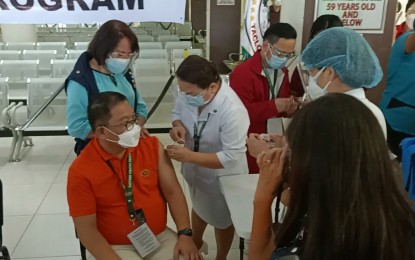 <p><strong>VACCINATION.</strong> Eastern Visayas Regional Medical Center chief of hospital Salvador Evardone receives the first dose of CoronaVac vaccine during a ceremony on Friday (March 5, 2021) in Tacloban City. The Department of Health is eyeing to vaccinate more than 27,000 health workers in Eastern Visayas listed as a top priority in the vaccination rollout. <em>(PNA photo by Roel Amazona)</em></p>