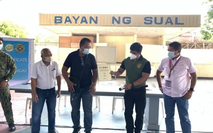 <p><strong>CLEARED.</strong> Philippine Drug Enforcement Agency (PDEA) Pangasinan provincial officer Dexter Asayco (second from right) hands over the certificate of drug-cleared status to Barangay Calombuyan chairman Eddie Amor (third from left) on March 8, 2021. Calombuyan is among the 1,039 drug-cleared barangays in the province. <em>(Photo courtesy of Sual Public Information Office Facebook page)</em></p>