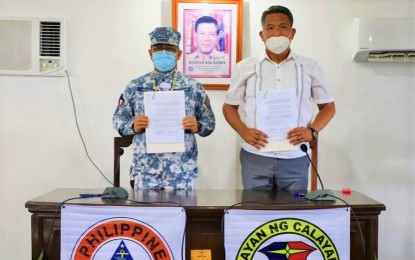 <p><strong>SIGNING. </strong>Philippine Coast Guard (PCG) Commandant, Admiral George Ursabia Jr. (left), and Calayan Island Mayor Joseph Llopis (right) present the signed deed of donation on Tuesday (March 9, 2021). The PCG is set to build stations and/or substations in the land donated to the PCG to enhance maritime security and safety in the region. (<em>Photo courtesy of PCG</em>) </p>