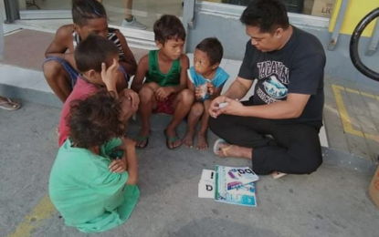 <p><strong>ILLITERACY TERMINATOR.</strong> Ryan V. Uy teaches street children basic reading in Barangay San Francisco, General Trias, Cavite in this undated photo. Ryan has been relentless in trying to figure out how to defeat the “rampaging bull” he called illiteracy, and eventually came up with his “Illiteracy Terminator”. <em>(Contributed photo)</em></p>